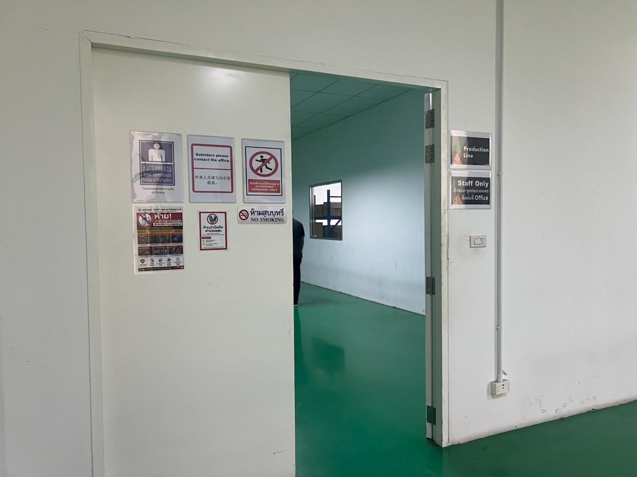 Authorized production floor entrance with Staff Only, No Smoking, No Mobile signage in English and Thai